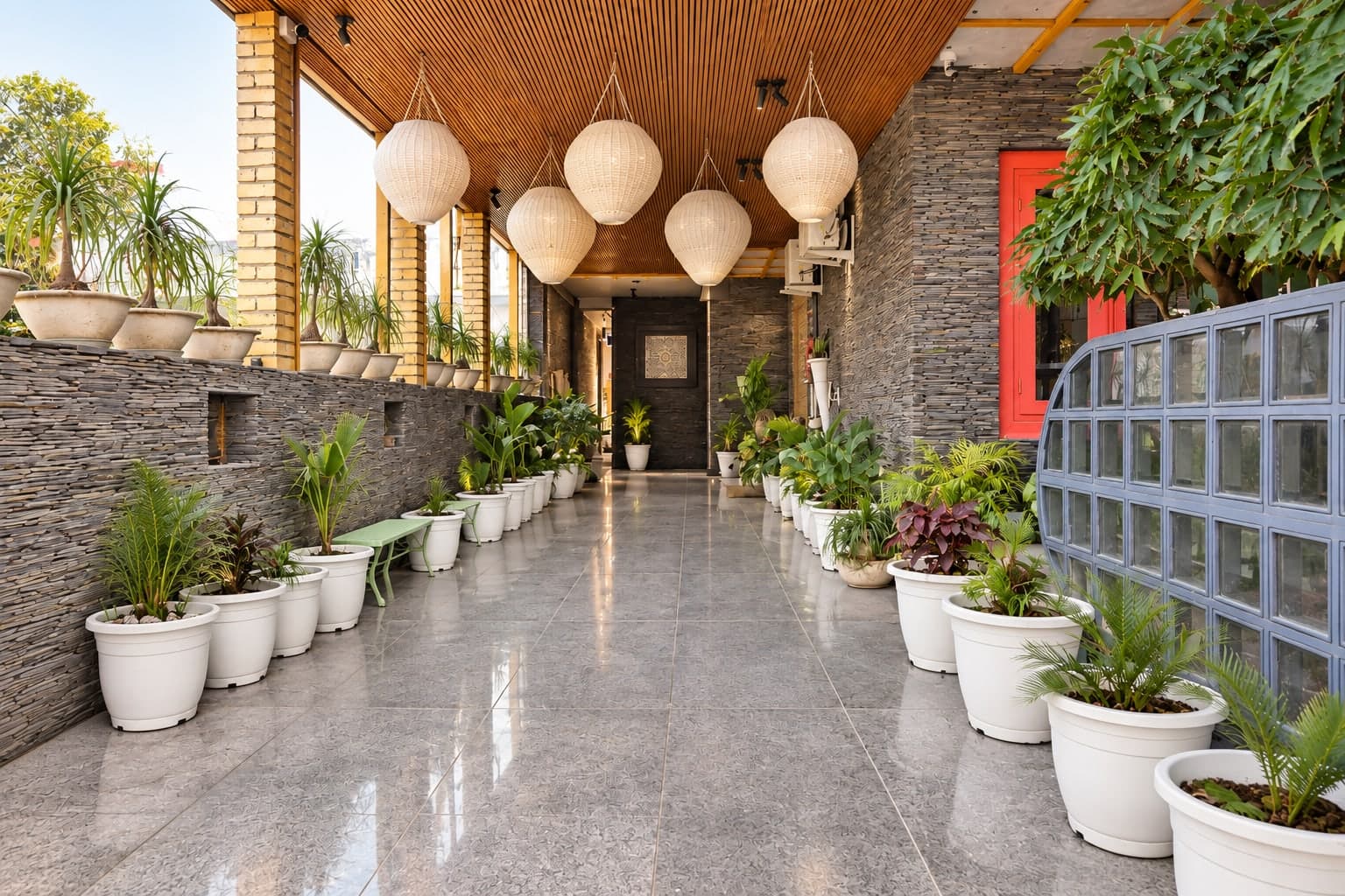 A stone corridor lit with lanterns at Aakriti Hotels